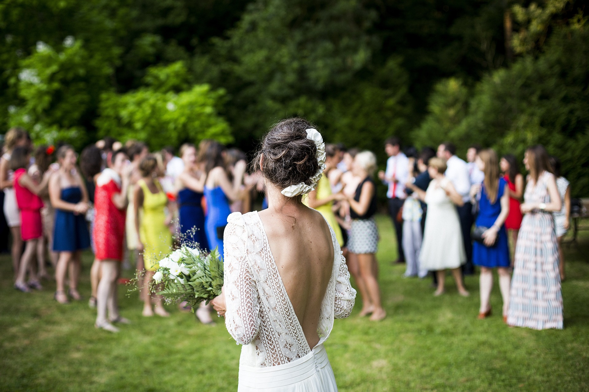 A woman prepares to throw the bridal bouquet at an outdoor event venue.